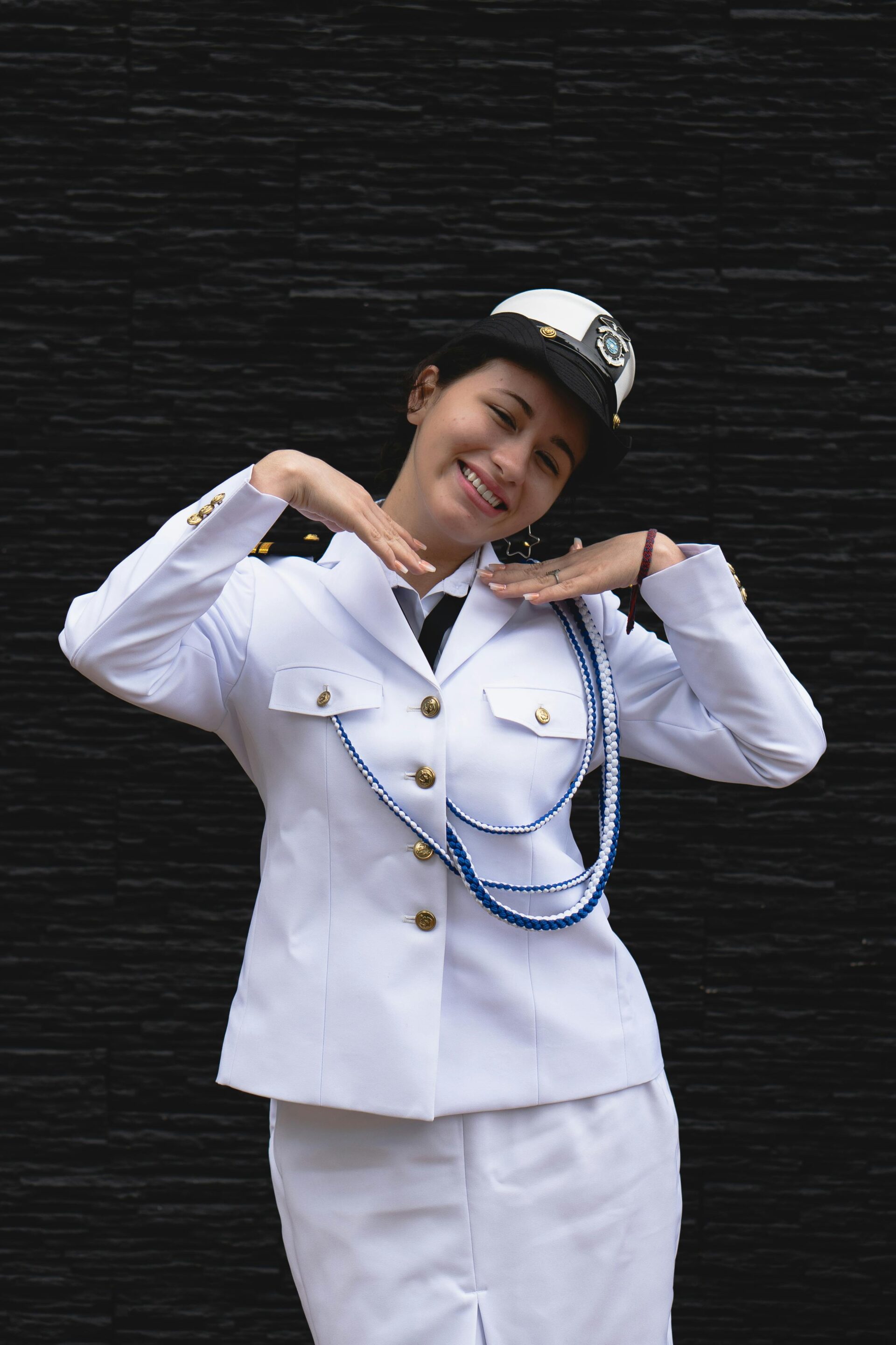 Women's formal white maritime officer uniform featuring decorative blue and white aiguillettes.